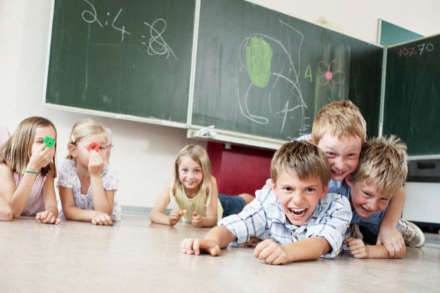 Children playing on floor in classroom --- Image by © Oliver Rossi/Corbis